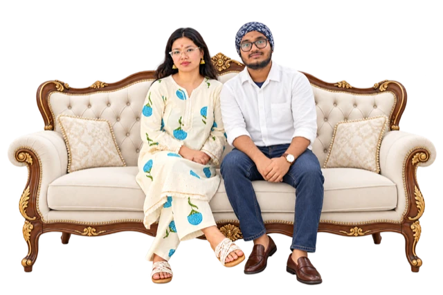 A couple seated on an illustrative ivory sofa with a carved walnut and gold frame.